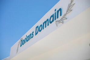 A sign with the text 'Dorian's Domain' against a clear blue sky. - Dorians Faliraki (Faliraki)