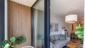 Uma sala de estar moderna com um sofá, um espaço de refeições e uma planta grande.
