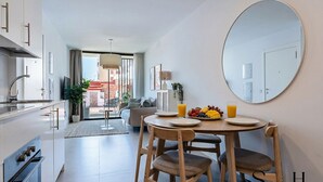 Cozinha moderna com área de refeições, um espelho redondo e vista para o exterior.