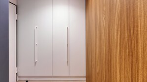 A room with a large wardrobe, a wooden panel wall, and a tiled floor. - Deluxe apartment with balcony (Split)