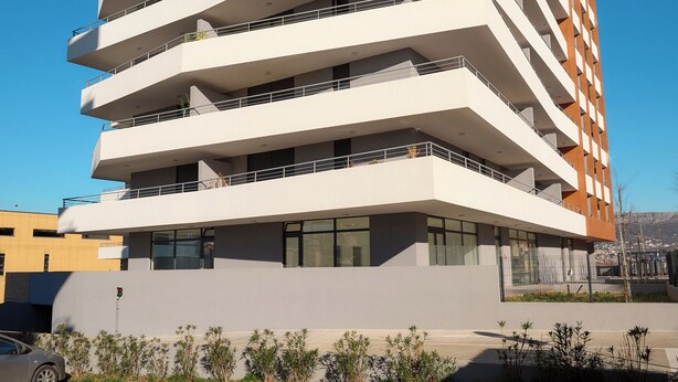 A multi-story building with balconies, a flat roof, and a clear sky. - Deluxe apartment with balcony (Split)