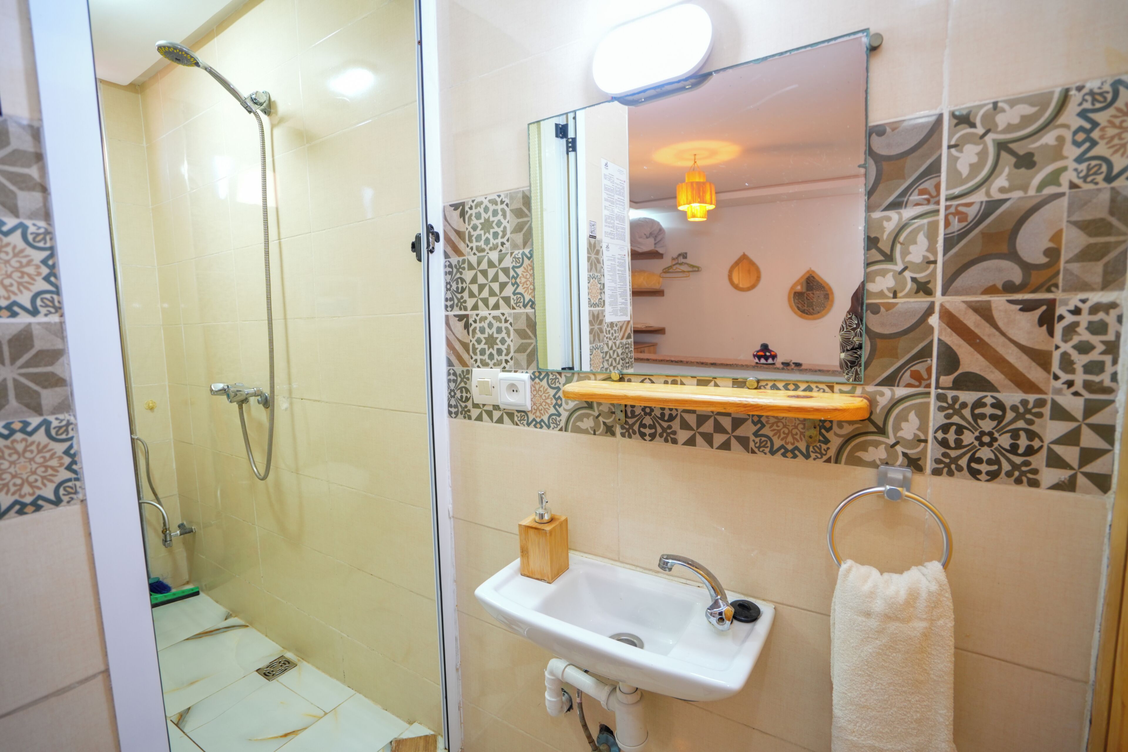 Un baño con ducha, lavabo y espejo.