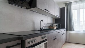 A modern kitchen with a built-in oven, a microwave, and a sink.