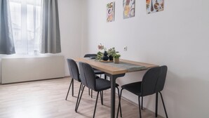 A dining area with a table, chairs, and artwork on the wall.