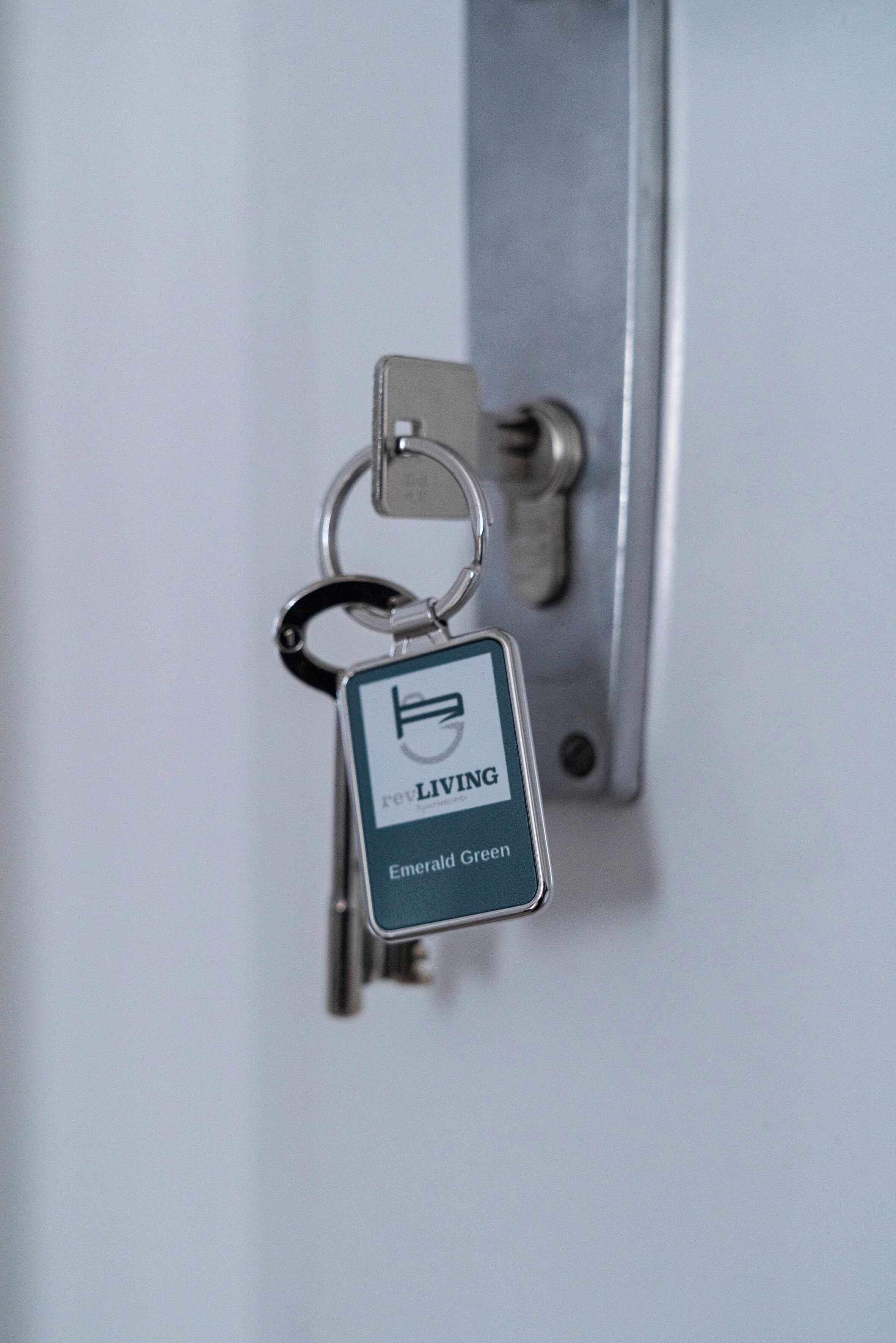 Un porte-clés avec un cadenas fixé à une poignée de porte.