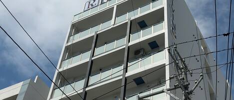 Ein mehrstöckiges Hotel mit einer auffälligen Beschilderung oben.