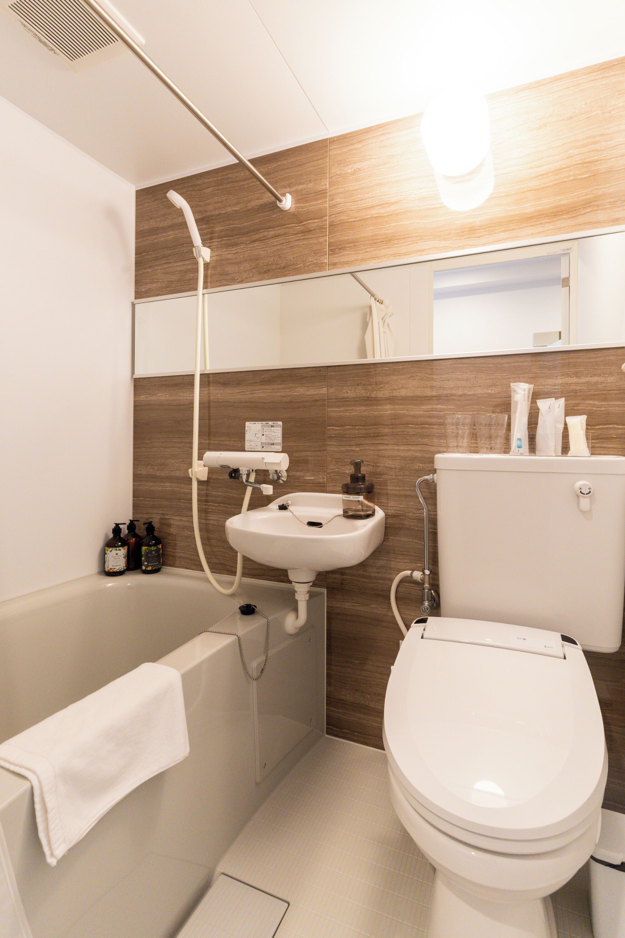 A modern bathroom with a bathtub, a sink, a toilet, and a shower.