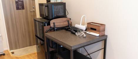 Una kitchenette compacta equipada con refrigerador, microondas y cafetera.