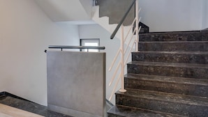 Una escalera con barandilla y un extintor en la pared.