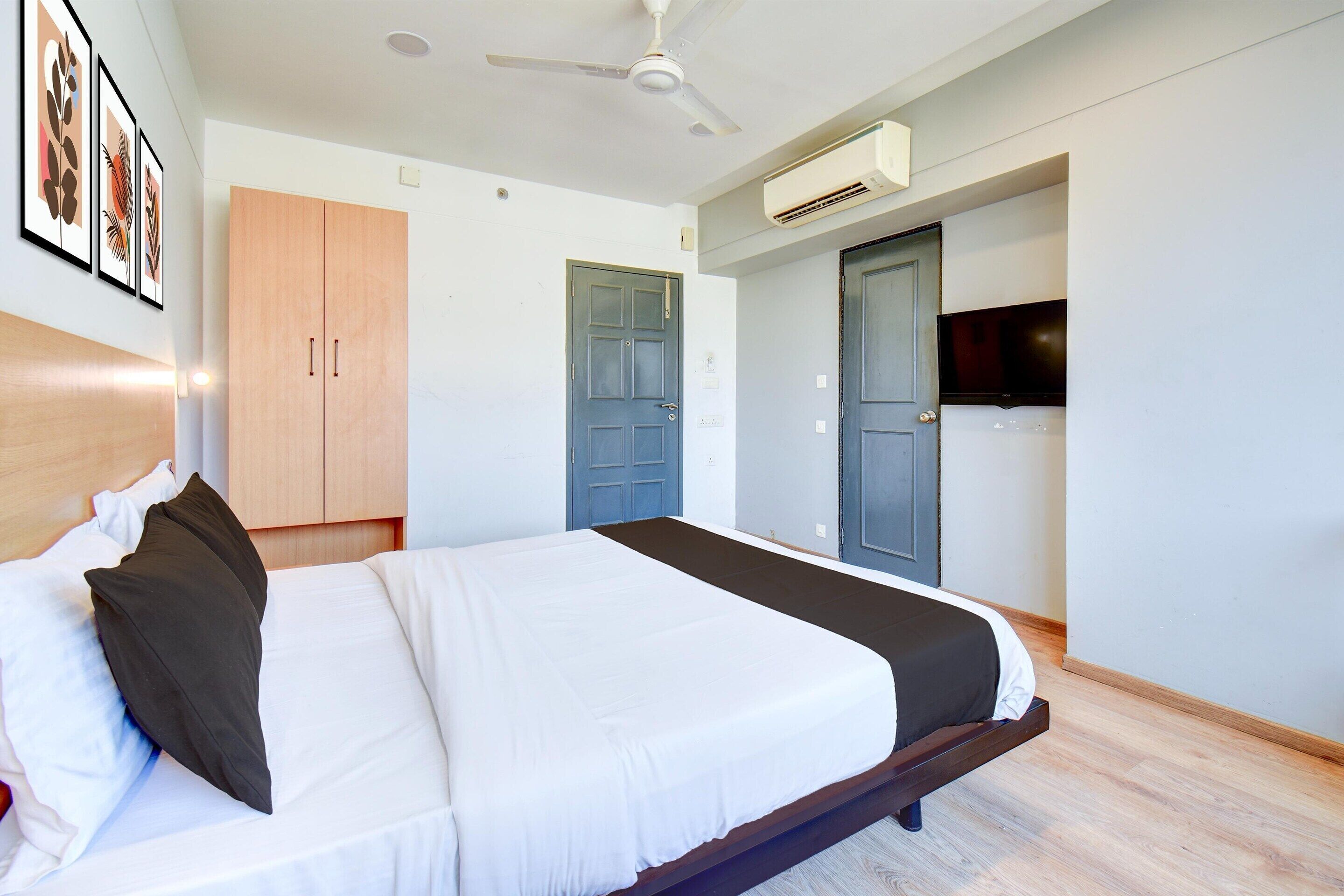 Un dormitorio con cama, armario, puerta y equipo de aire acondicionado.