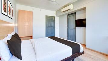 Un dormitorio con cama, armario, puerta y equipo de aire acondicionado.