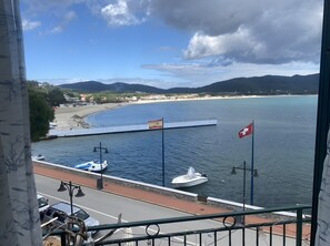 Vista costera con un puerto deportivo, barcos y una bandera.