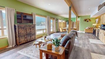 A spacious living area with a sofa, wooden table, and a view of the outdoors.