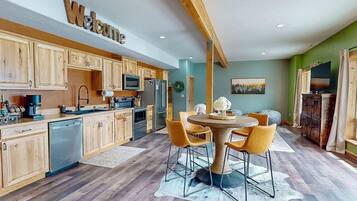 A modern kitchen with wooden cabinets, a central island, and a 'Welcome' sign.