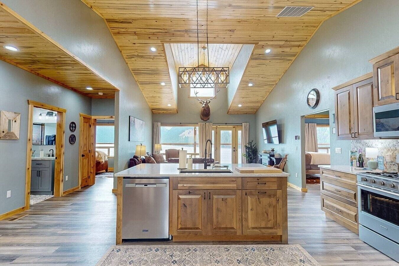 Una cocina amplia con armarios de madera, una isla central y un ventanal grande.