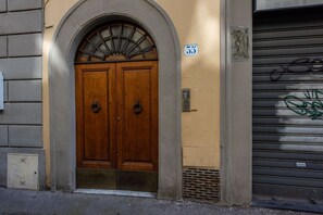 A double wooden door with a fanlight above, a number 35 sign, and a closed metal shutter to the right. - Da Mamma Grazia in Oltrarno by MMega Homes and Villas (Florence)
