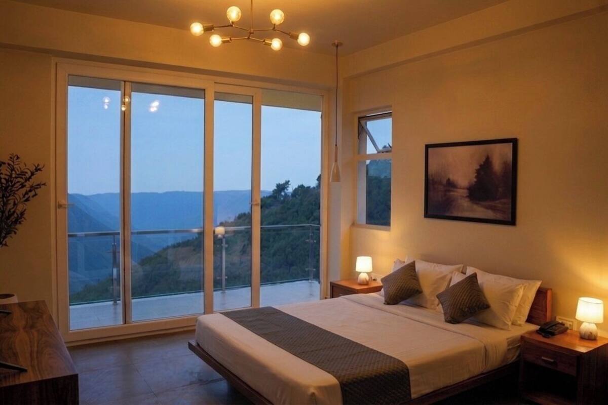 A bedroom with a large bed, two bedside tables, a nightstand, a floor lamp, a painting, and a view of the outdoors.
