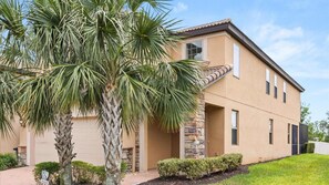 A two-story house with a stone facade, a garage, and a well-maintained lawn. - Upstay- Family Villa for 12 w Pool Games BBQ (Kissimmee)
