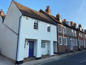A row of terraced houses with white and brown facades, a blue door, and a clear sky. - 19 Queen Street (Emsworth)