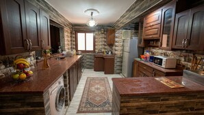 Una cocina con armarios de madera, lavadora, microondas y cafetera.