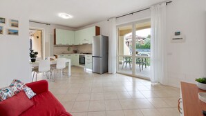 Un apartamento moderno con cocina, comedor y sala de estar con un sofá rojo.