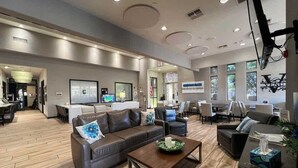 A spacious lobby with a reception desk, seating area, and large windows. - Indigo-Communal Pool, Hot Tub, Gym & Movie Theater (Scottsdale)