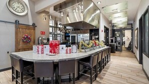 A modern kitchen with a central island, stainless steel appliances, and a wooden door with a wreath. - Indigo-Communal Pool, Hot Tub, Gym & Movie Theater (Scottsdale)