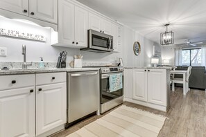 A modern kitchen with white cabinetry, stainless steel appliances, and a granite countertop. - 'folly Tides' HHI Condo w/ Beach, Pools & Tennis! (Hilton Head Island)
