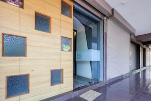 Fachada moderna de un edificio con paneles de madera y diseños geométricos de vidrio.