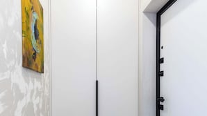 Een kamer met een witte deur, een beige mat en een schilderij aan de muur.