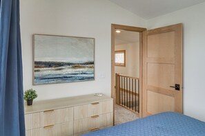 A bedroom with a bed, a dresser, a painting, and a wooden door. - Family-friendly Lake Ida Escape: Stunning Views! (Alexandria)