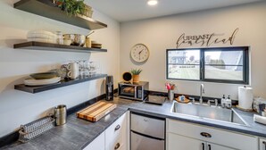 Una cocina moderna con electrodomésticos integrados, un reloj y una ventana con vistas.