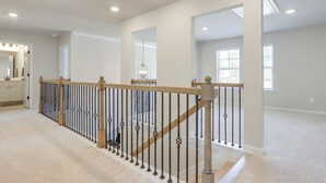 A spacious interior with a staircase, a kitchen area, and large windows. - Race Days & Family Fun! Spacious Locust Grove Home (Locust Grove)