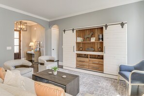 A living room with a sofa, coffee table, and a sliding barn-style closet. - 3 Mi to Old Hickory Lake! Luxe Family Getaway (Mount Juliet)