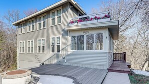 A two-story house with a deck, a covered porch, and a window with a flower box. - Walk to Beach! Serene Lake Michigan Home w/ Deck (Grand Haven)