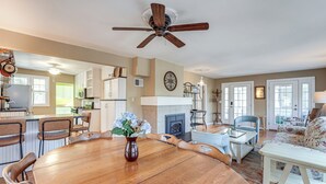 A spacious living area with a wooden dining table, a ceiling fan, and a fireplace. - Walk to Beach! Serene Lake Michigan Home w/ Deck (Grand Haven)