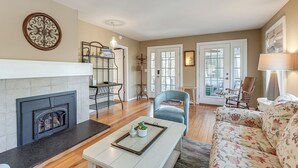A living room with a fireplace, a sofa, a coffee table, and a chair. - Walk to Beach! Serene Lake Michigan Home w/ Deck (Grand Haven)