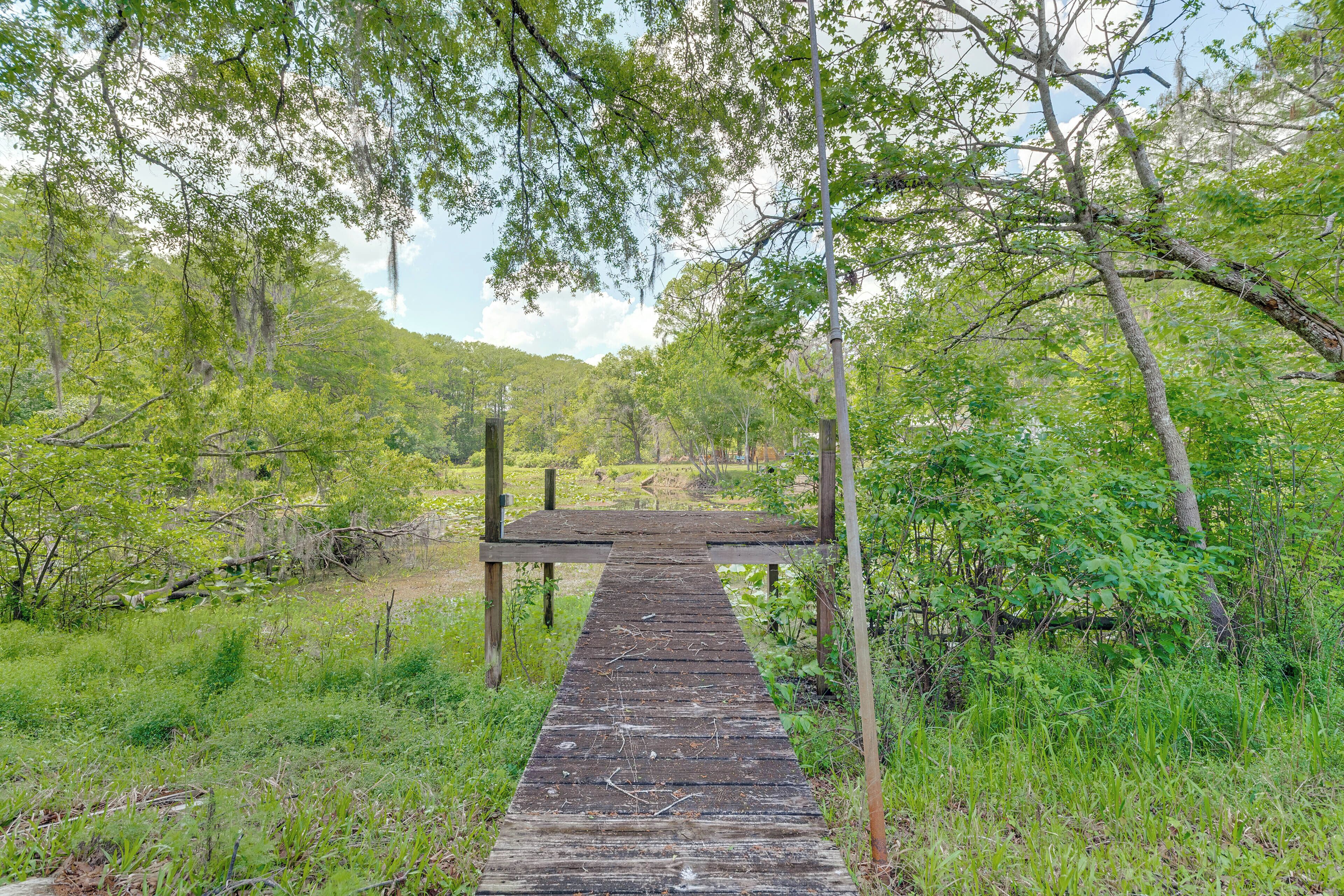 A wooden pathway leading to a wooden structure in a forested area.