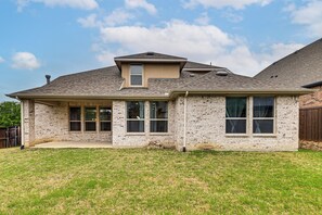 A single-story house with a brick exterior, a gabled roof, and a front porch. - Near Lake & Family Fun! Spacious Oak Point Home (Little Elm)