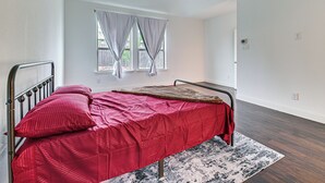 A bedroom with a bed, a ceiling fan, a window with curtains, and a rug. - Near Lake & Family Fun! Spacious Oak Point Home (Little Elm)