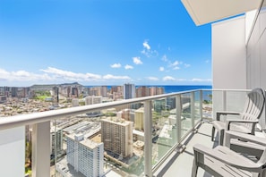 Ein Balkon mit Blick auf eine Stadtlandschaft und das Meer.