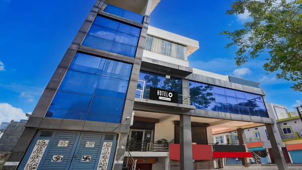A modern hotel with a glass facade, a sign reading 'HOTEL,' and a visible entrance. - Classic Hotel Shimla Grand (Lucknow)