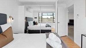 A modern bedroom with a bed, bedside tables, a wardrobe, and a large window. - 4BR Carlisle Stay Near Airport & Stadium  Sleeps 8 (Carlisle)