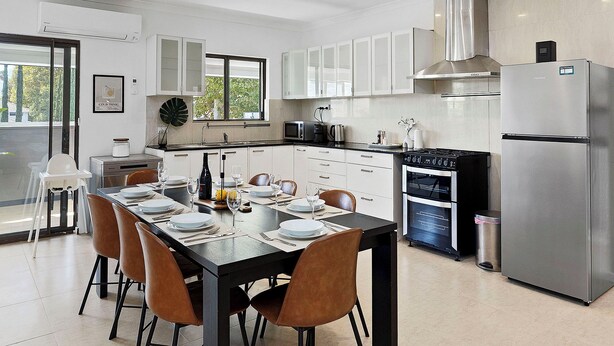 A modern kitchen with a dining area, stainless steel appliances, and a large window. - 4BR Carlisle Stay Near Airport & Stadium  Sleeps 8 (Carlisle)