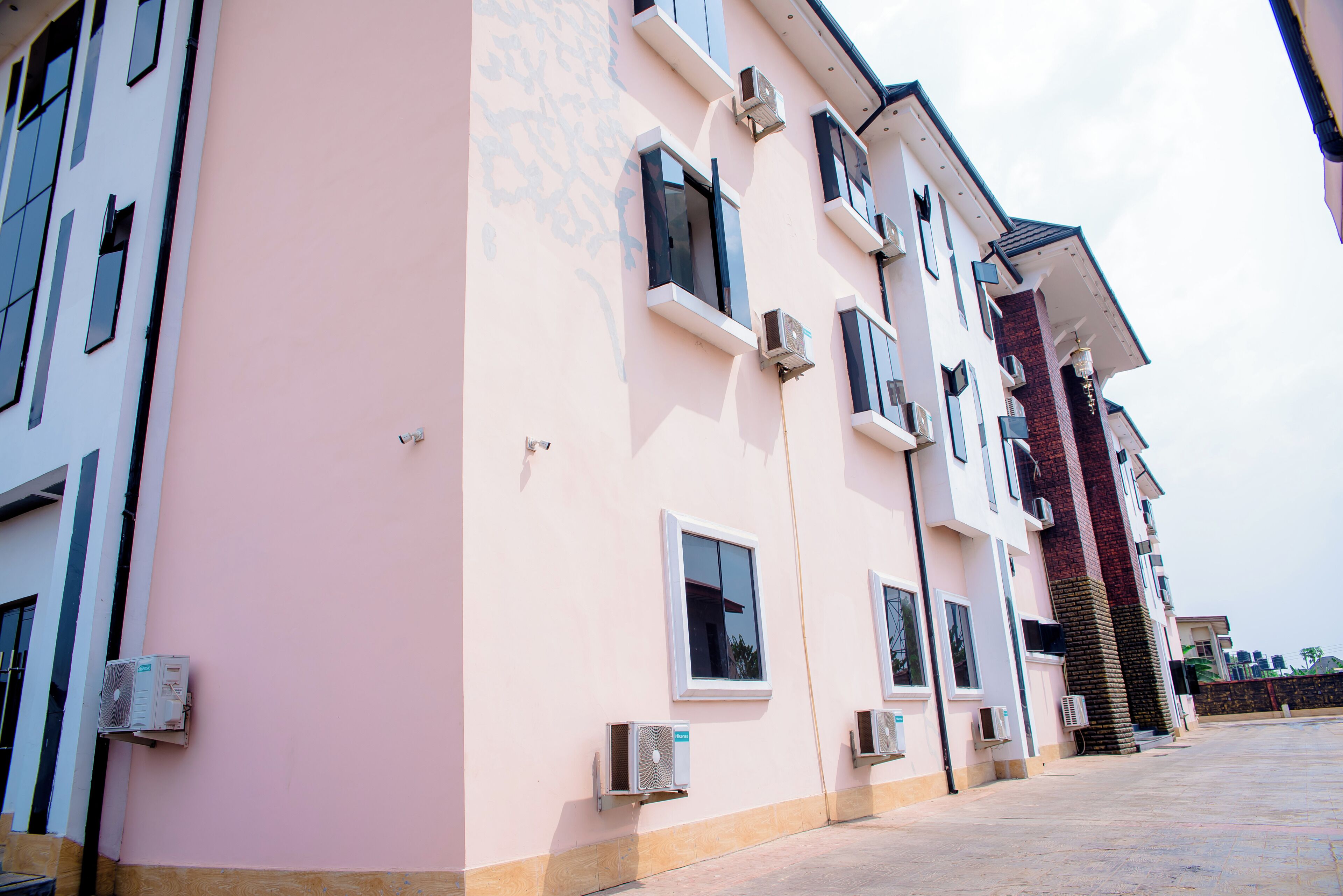 A multi-story building with air conditioning units, a brick staircase, and a flat entrance area.