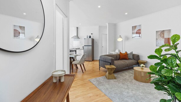 Ein modernes Wohnzimmer mit einer Couch, einem Couchtisch und einem Essbereich mit Stühlen.