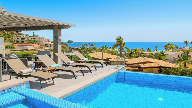 A swimming pool with lounge chairs, a covered area, and a view of the ocean. - Walk to Beach Modern Oceanview Villa w/ 2 Pools, Hot Tub & Concierge Cabo (Cabo San Lucas)