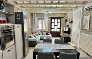 A compact living space with a kitchenette, a sofa, a dining table, and a TV. - Casa Joanna Old Town Rethymno (Rethymno)