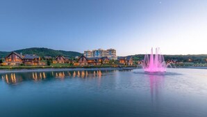 A lakeside resort with a large building, a fountain, and a calm lake. - Quba Palace Hotel & Golf Resort (Quba)