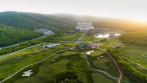 A golf course with a large building in the background. - Quba Palace Hotel & Golf Resort (Quba)